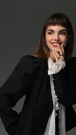 Студійне фото дівчини в чорному піджаку та білій блузці