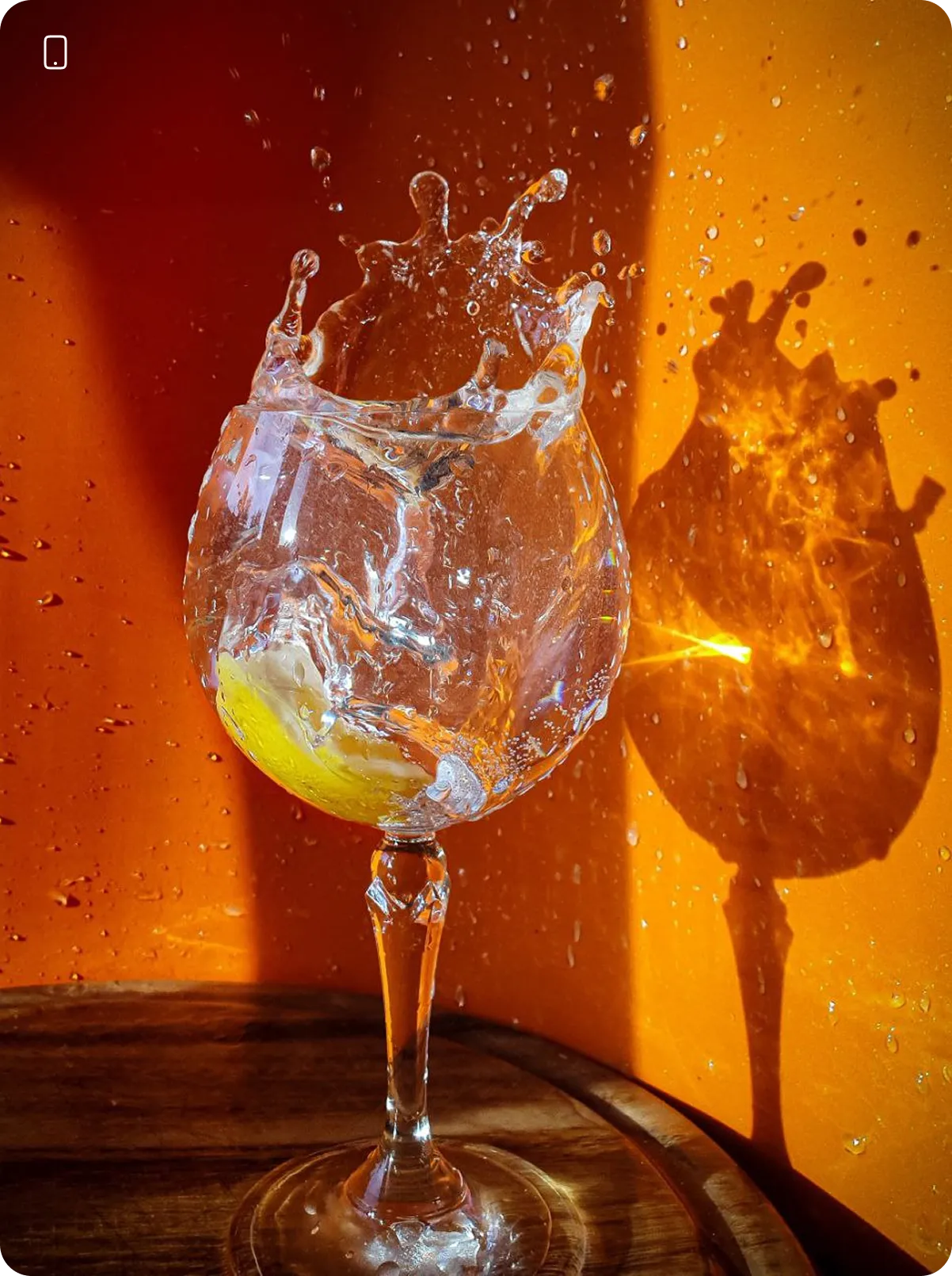 Результати студентів з курсу фуд та предметна зйомка. Бокал з водою, краплі води розлітаються на приємно теплому освітленні