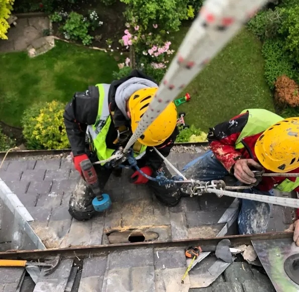 A rope access technician is fixing the chimney