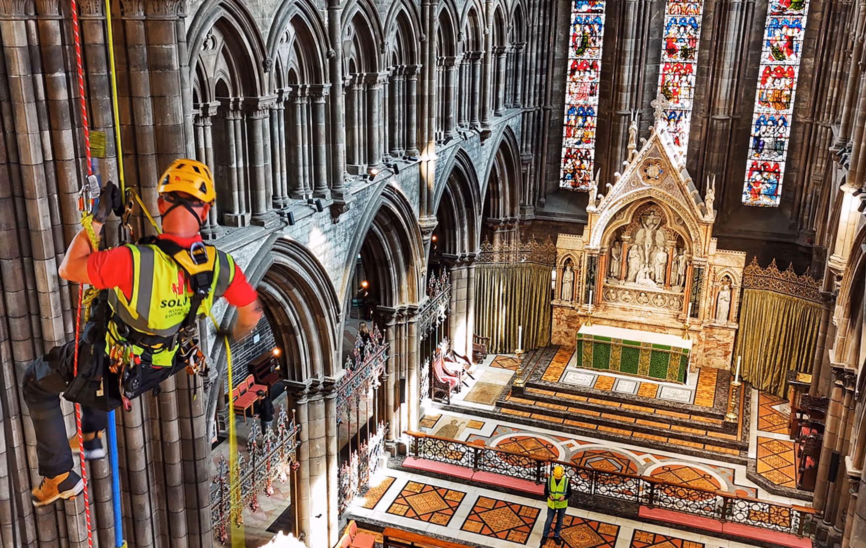 A rope access technician is fixing the wall