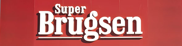Super Brugsen butikskilt med hvid tekst på rød baggrund.