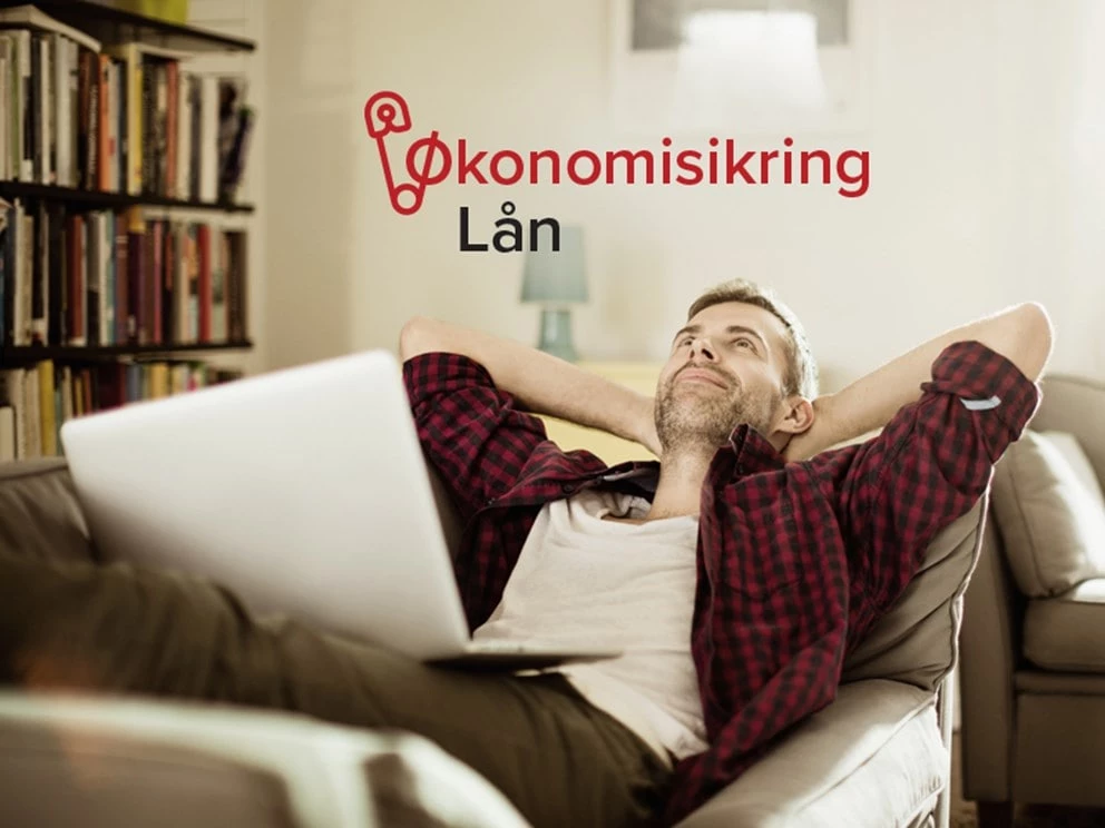 Mand slapper af med bærbar computer på skødet på en sofa i et hyggeligt rum med bogreol.