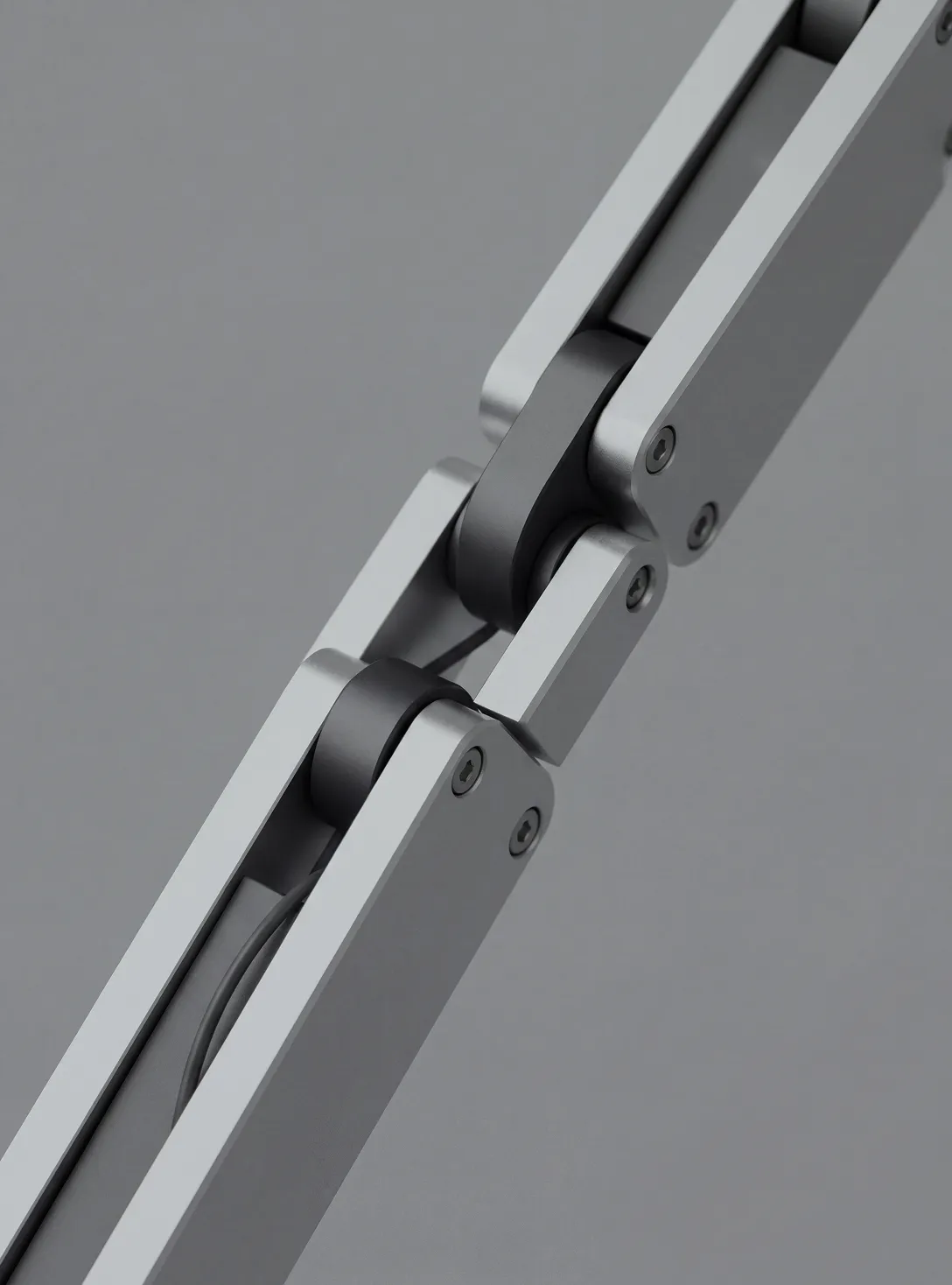 Close-up of a metallic hinge joint connecting two rectangular arms with visible screws and pivot points.