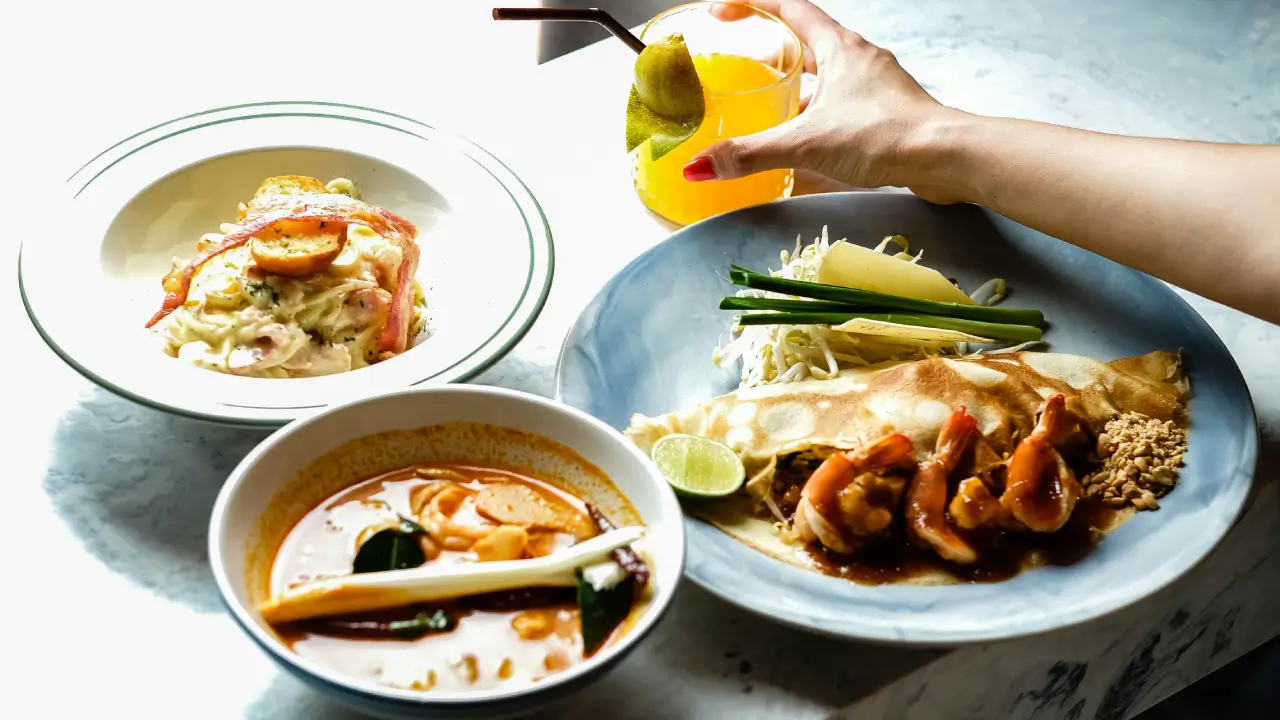raditional Asian cuisine dishes including ramen, dim sum and Thai curry displayed on a wooden table