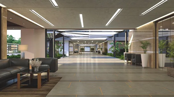 Modern lobby area with tiled floor, black leather sofas, glass coffee table, plants, and a long hallway with overhead lighting.