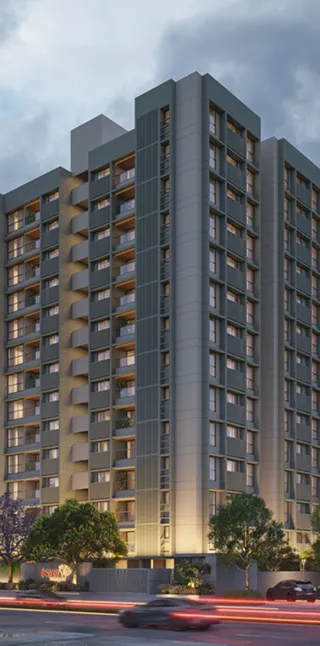 Modern multi-story apartment building with illuminated windows and surrounding trees at dusk.