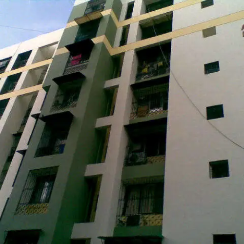 Low-angle view of a multi-story apartment building with balconies and windows.