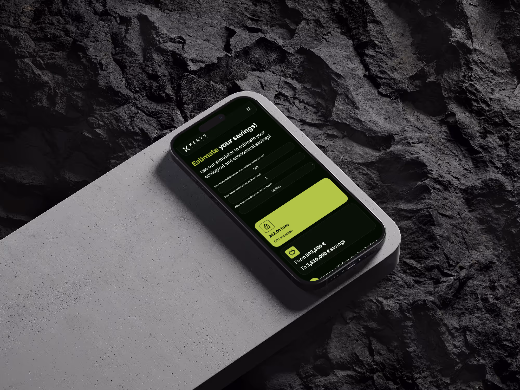 Smartphone on a concrete block displaying Kerys Software website with savings estimate and CO2 reduction calculator.