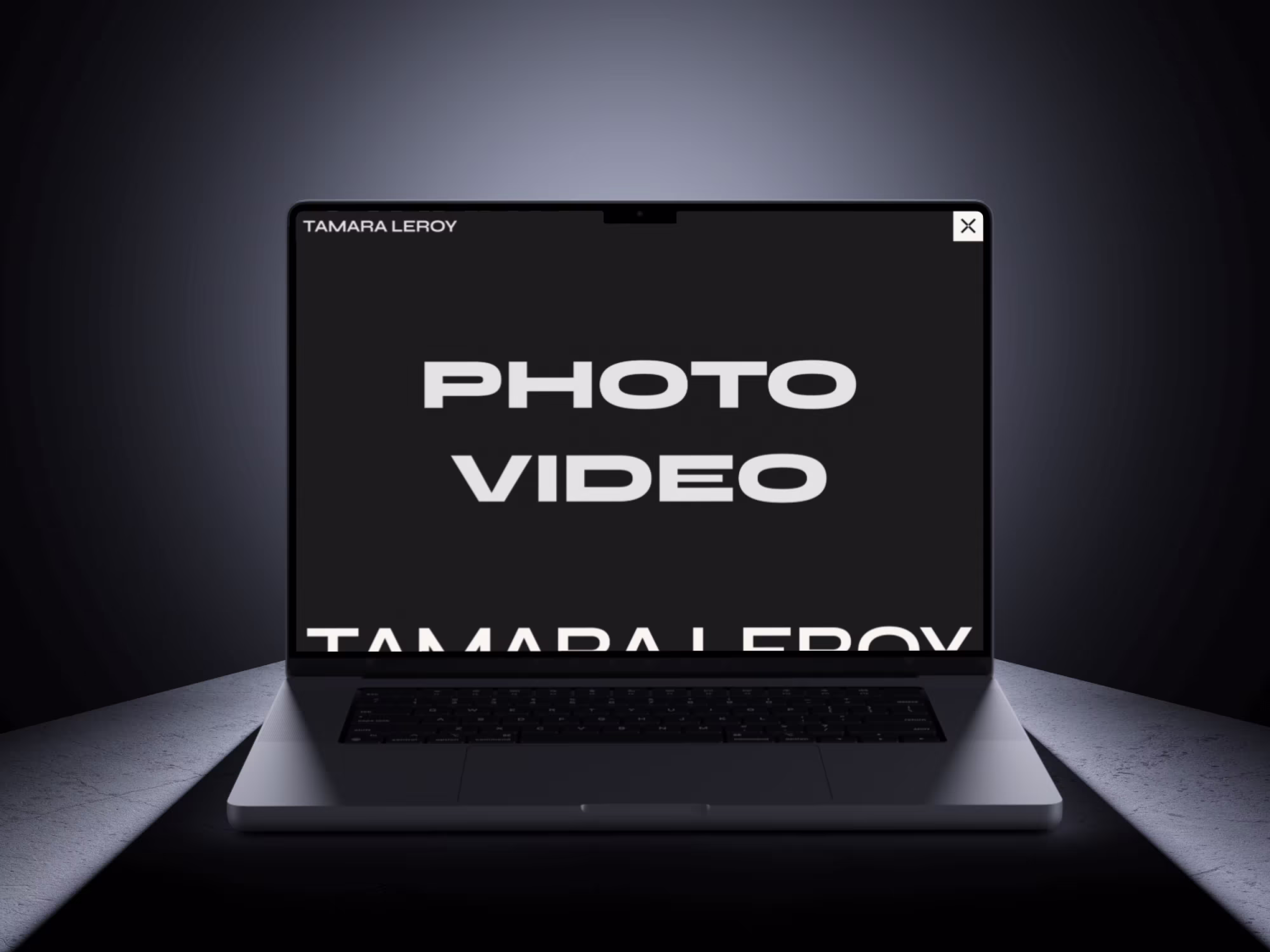 Silver laptop floating in the shadow, screen displaying text: PHOTO VIDEO TAMARA LEROY.