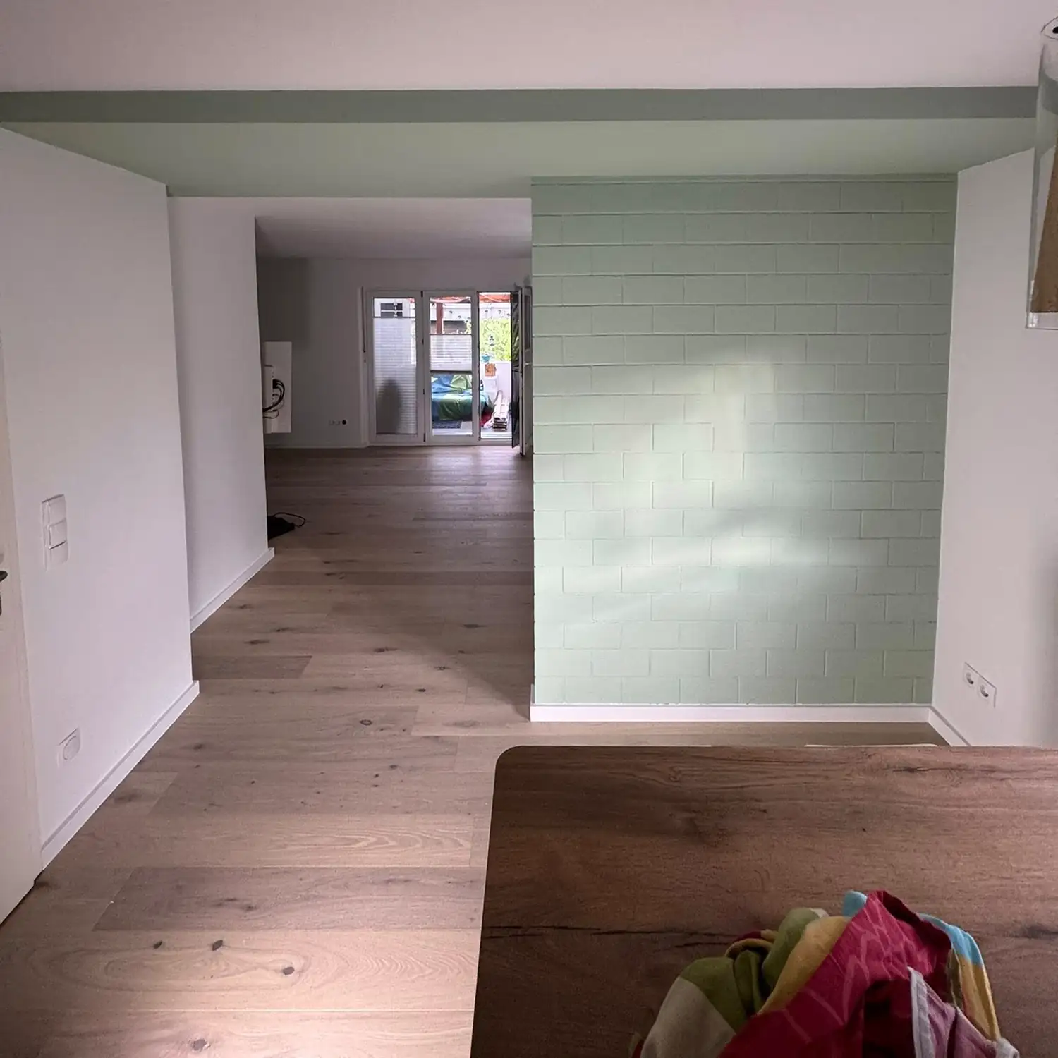 Fertig sanierter Wohnbereich mit neuem Holzboden und Akzentwand.
