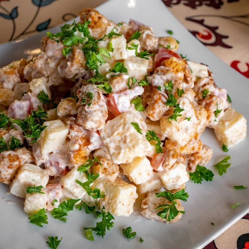 A white plate with a salad on it.