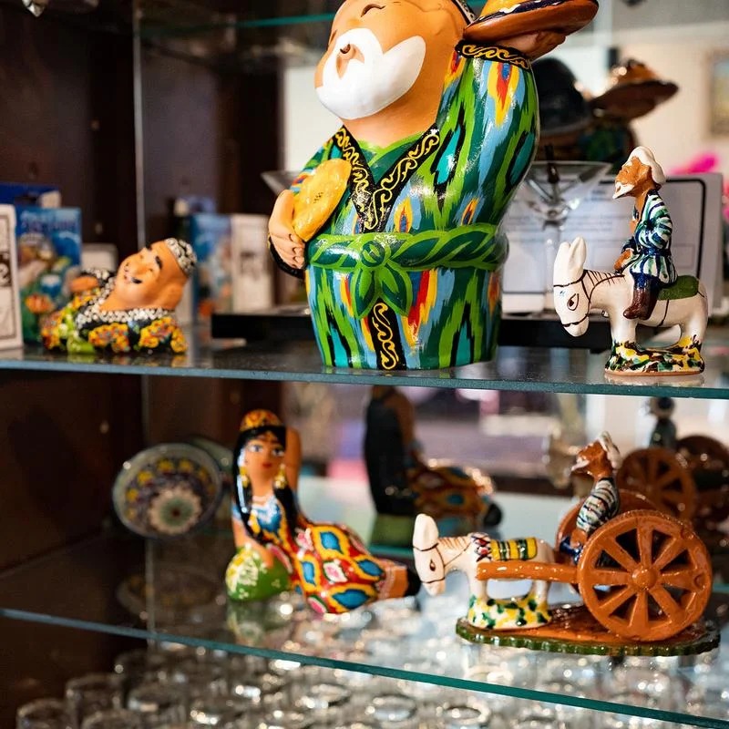 A glass case with a variety of figurines and glasses.