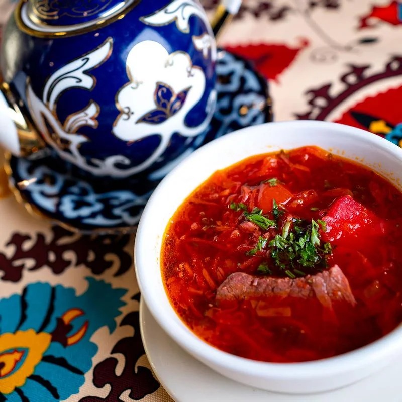 A bowl of Russian soup filled with tender meat and colorful vegetables, garnished for a hearty meal.