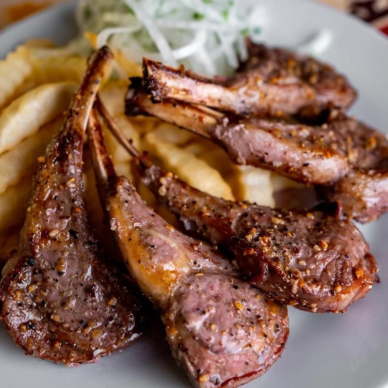 A plate of meat and fries with a green salad on the side.