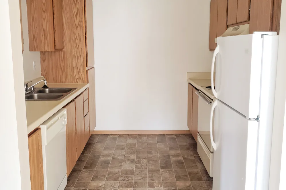 Kitchen with brown cabinets and white appliances