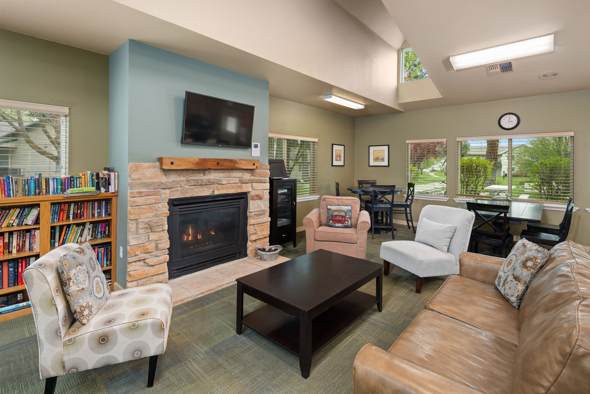 Clubhouse with seating area featuring chairs, coffee table, and book shelf with books