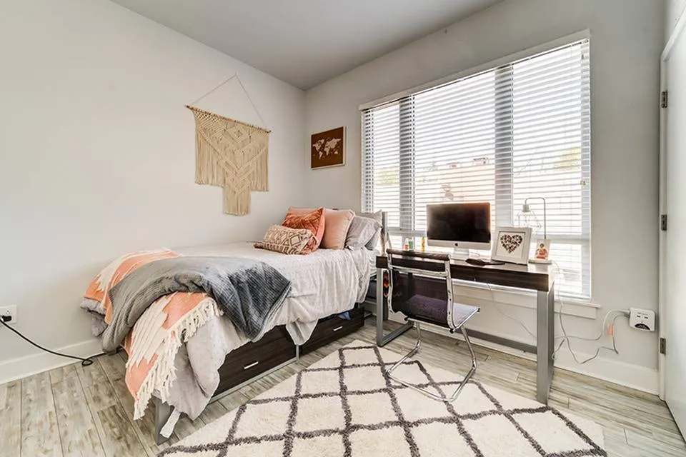 Furnished bedroom with bed and desk with chair