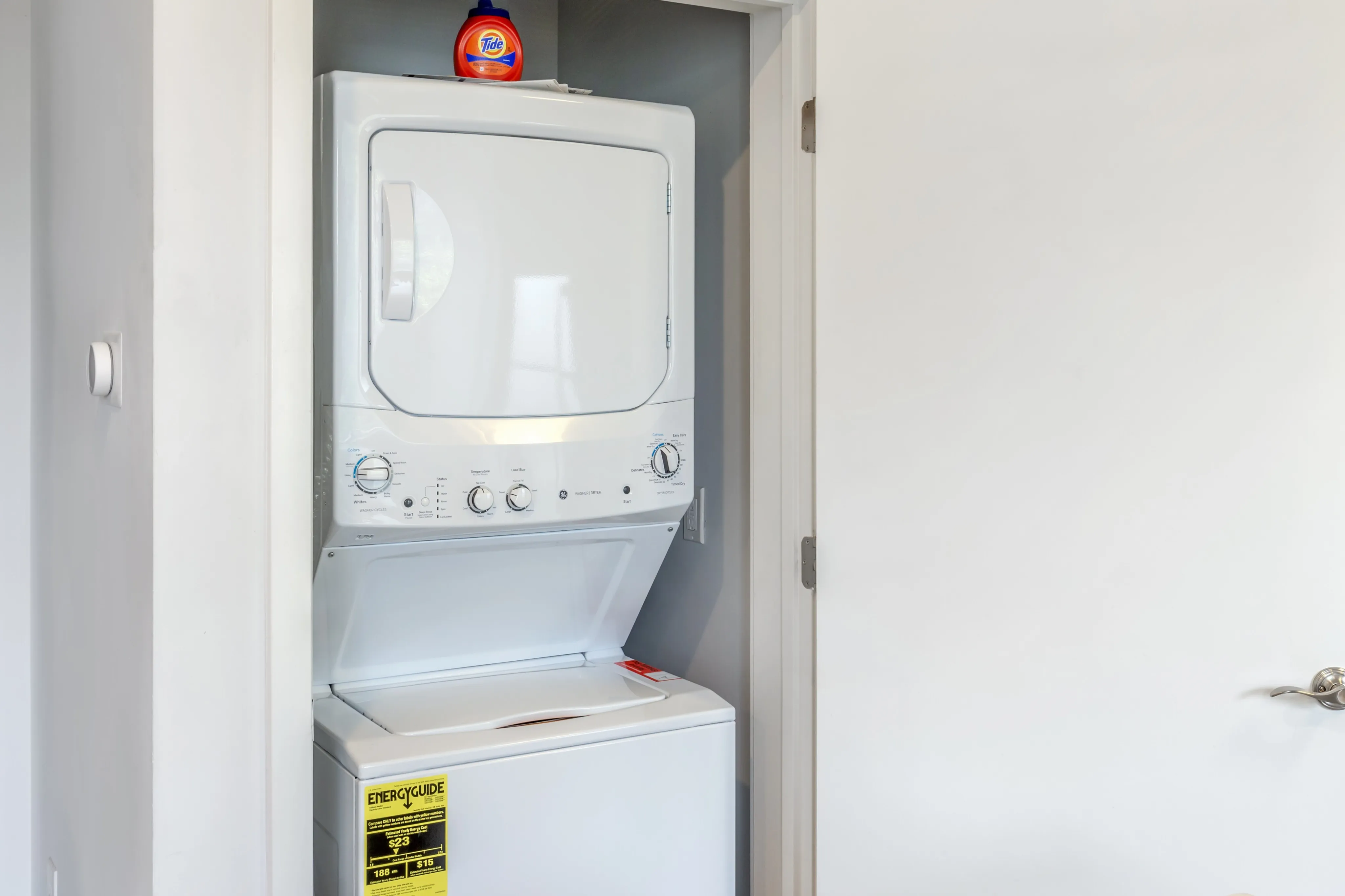 laundry room with white stacked laundry machines