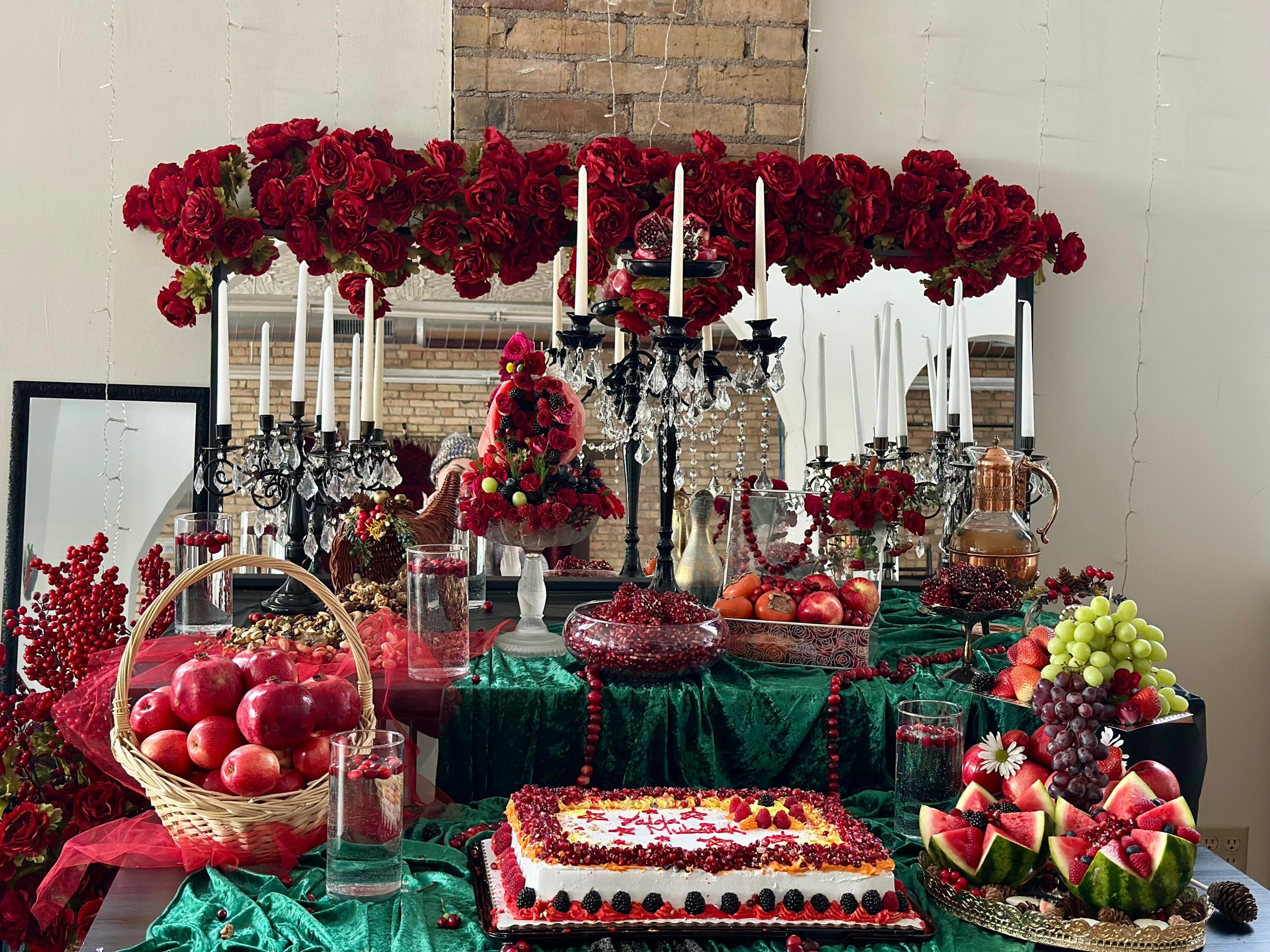 A table spread with read fruits and flowers like watermelon and pomegranite for Shab e Yalda