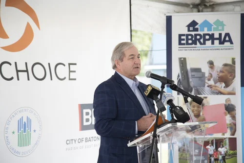 Man in blue suit speaks at podium with BR Choice and EBRPHA logos in background.