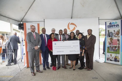 Large group of officials poses with the $29.5M HUD grant check.