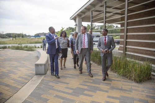 Officials tour the walkway outside the McKay Automotive Technology Center.