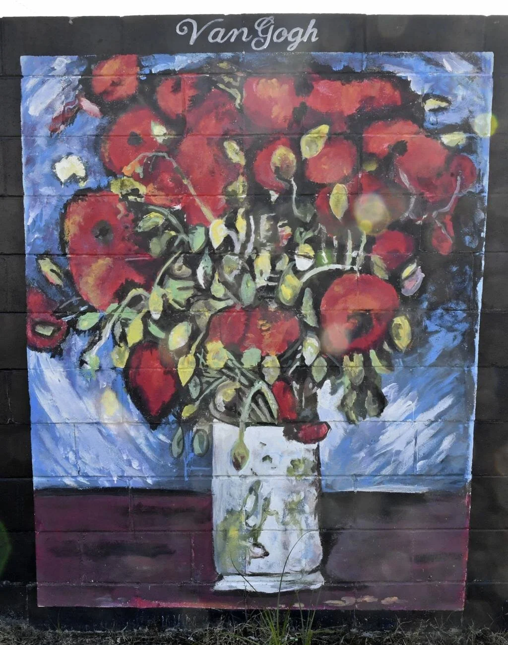 A mural of a vase filled with red flowers and green leaves, painted in an impressionist style with "Van Gogh" written above.
