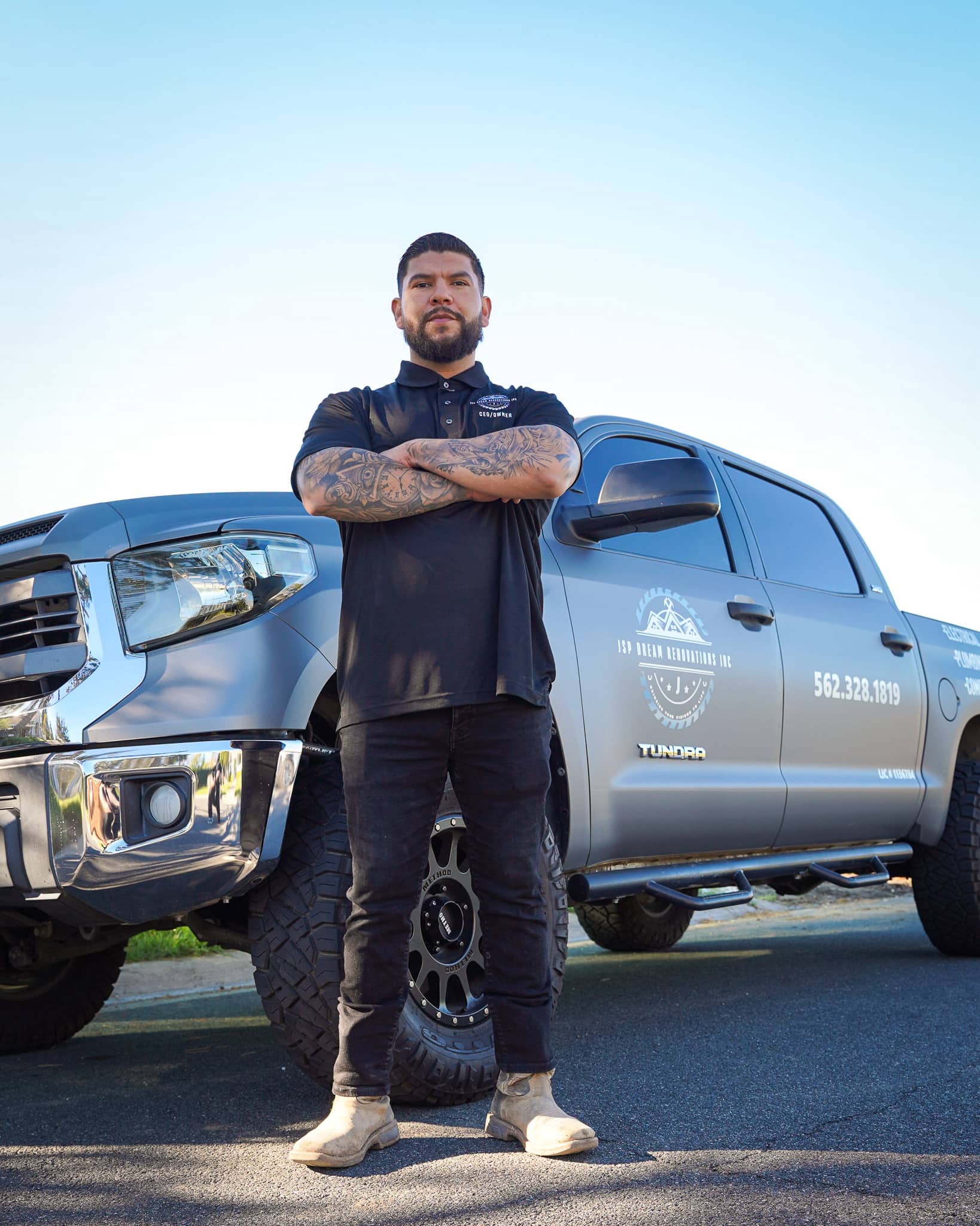 Smiling family of three posing on a wooden walkway at night, with the child holding a white lantern.