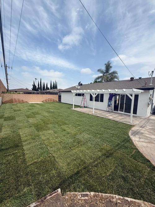 Construction workers renovating an interior space with exposed brick walls and supporting beams.
