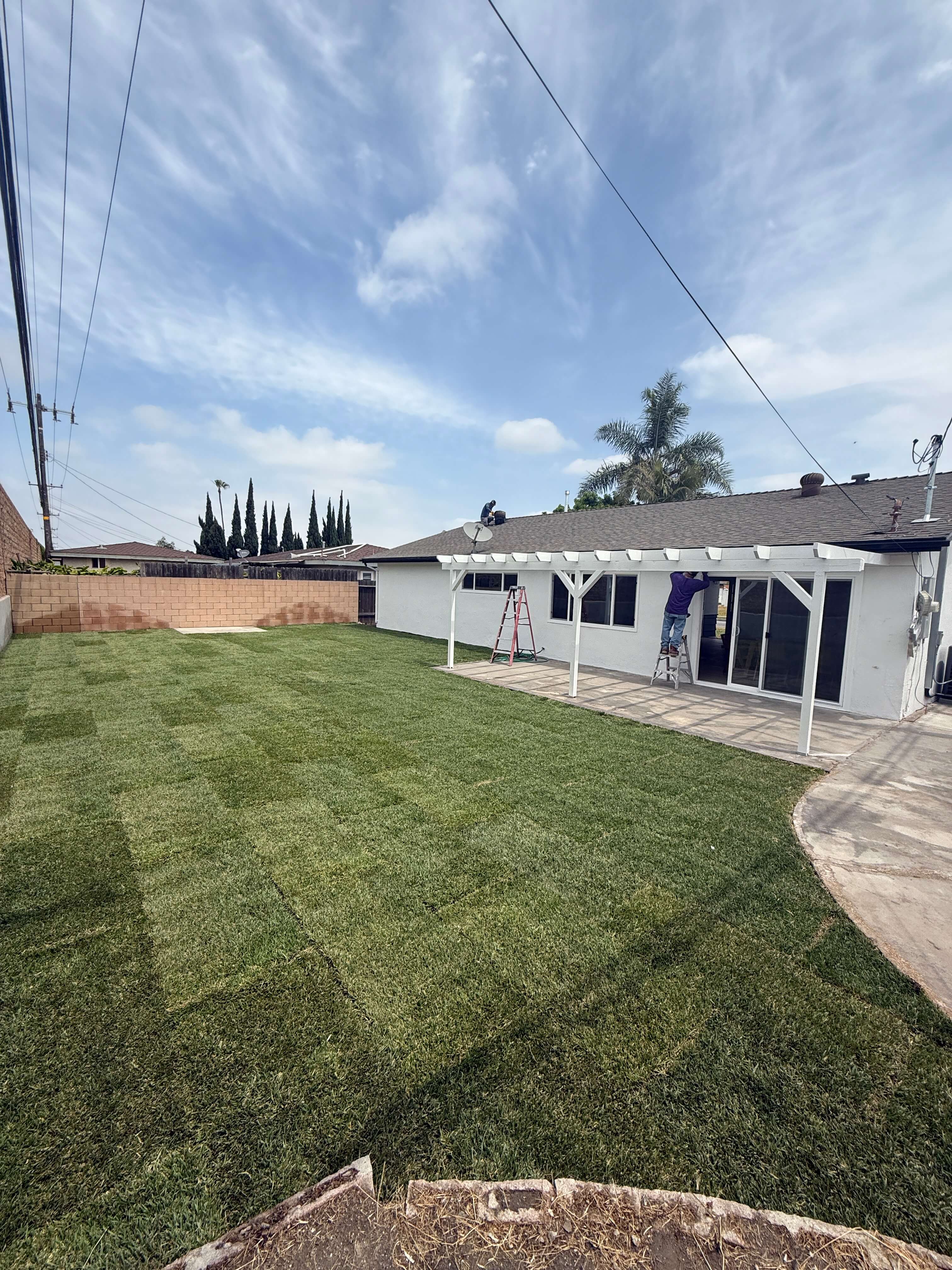 Construction workers renovating an interior space with exposed brick walls and supporting beams.