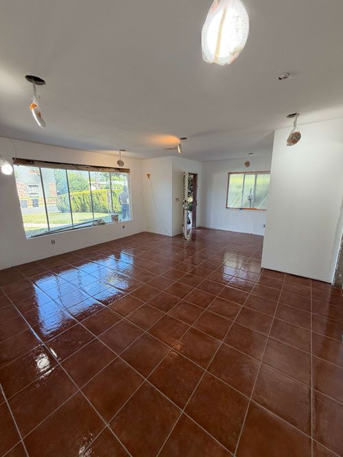Construction workers renovating an interior space with exposed brick walls and supporting beams.