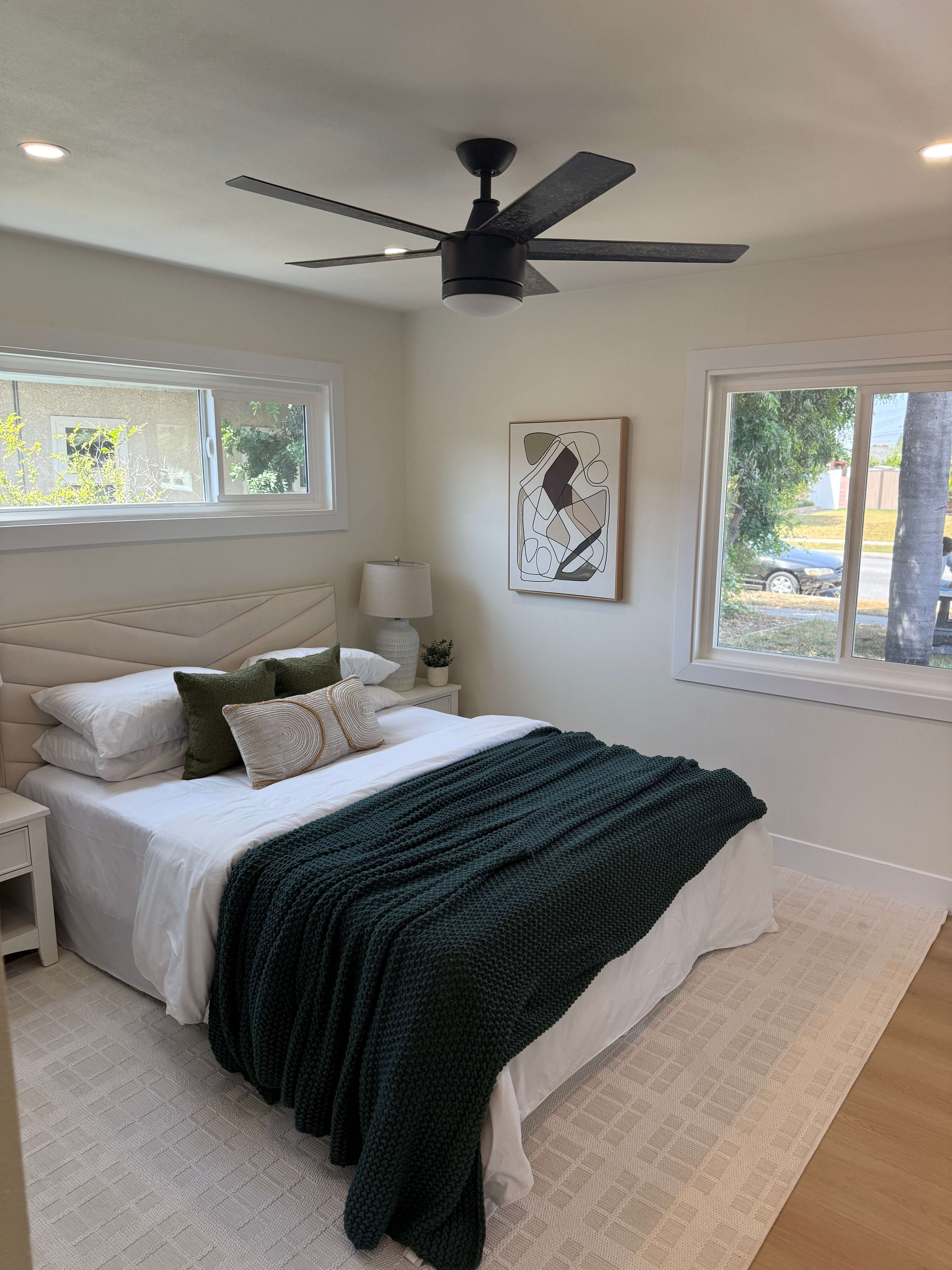 Bright kitchen under renovation with cabinets, countertop covered in protective plastic, and a folding ladder.