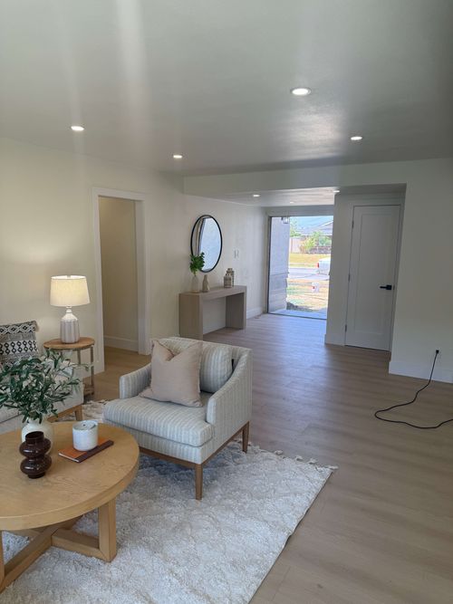 Construction workers renovating an interior space with exposed brick walls and supporting beams.