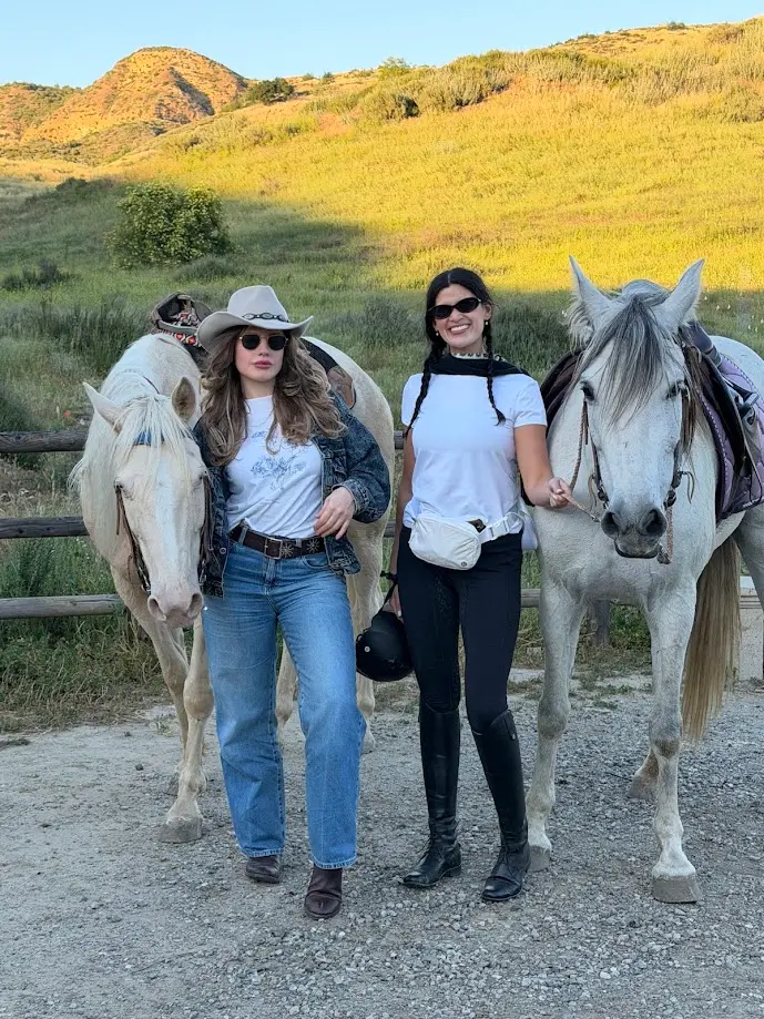 Women standing with horses after their first successful horseback riding experience