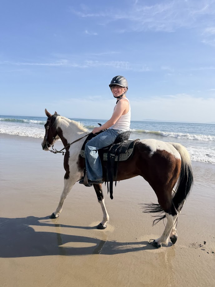 Rider on horseback at Rincon Beach with ocean waves in background