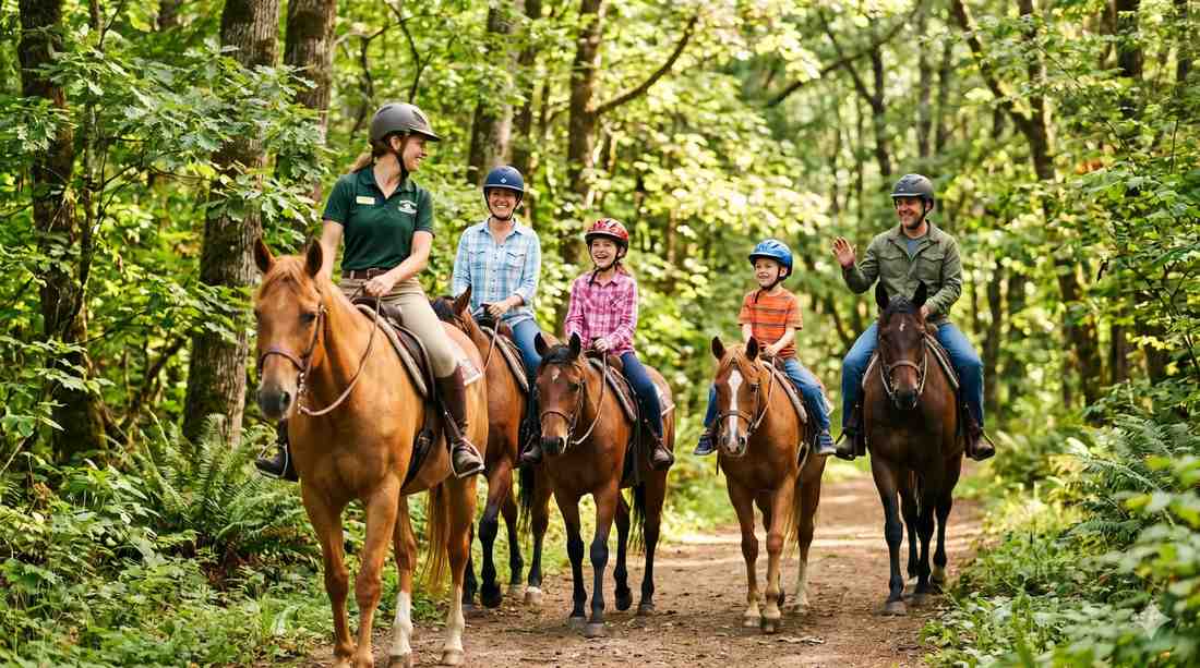Family of four on guided horseback trail ride through lush forest with trail guide