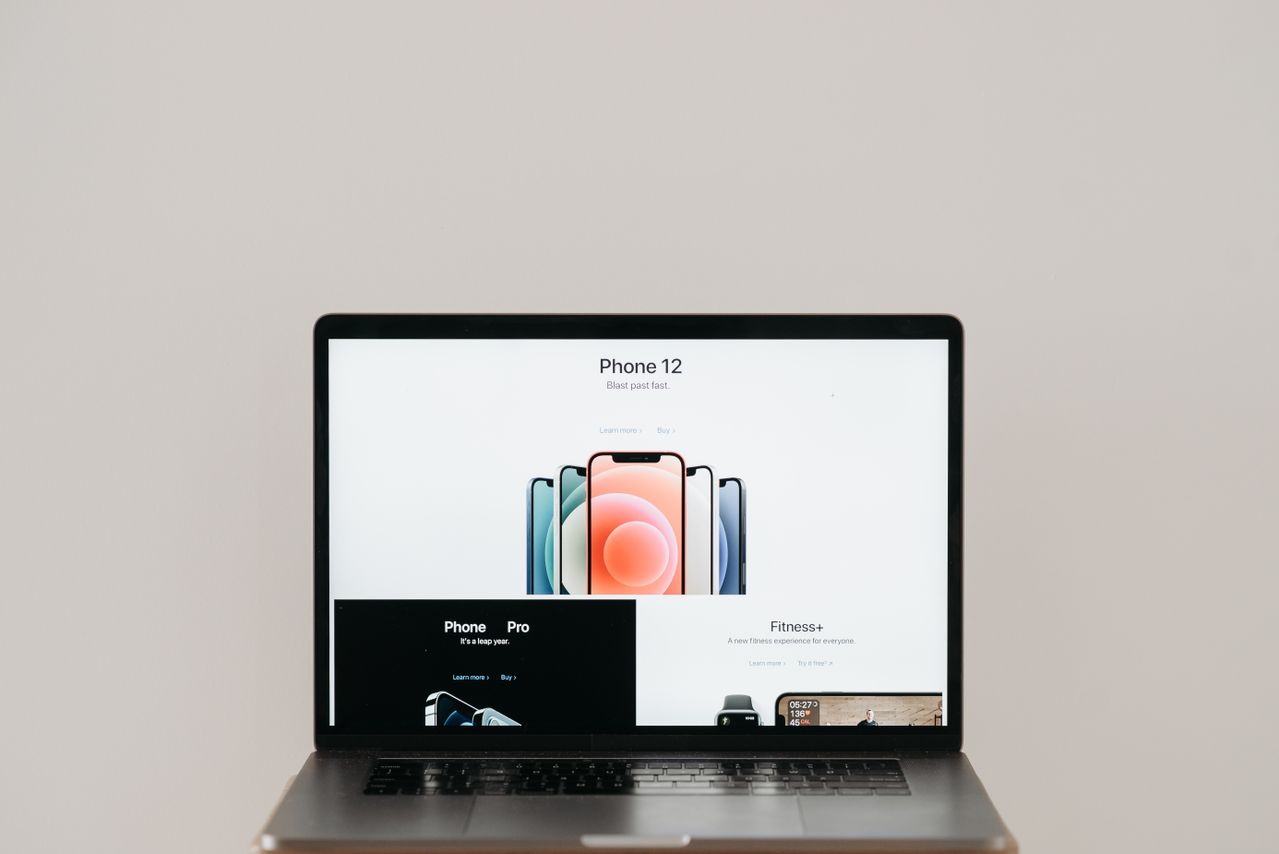 Laptop on stool showing Apple ad on white background.