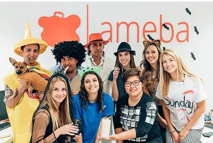 A diverse group of adults wearing Halloween costumes in a top creative marketing agency’s office.