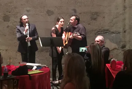 Three creative marketing professionals singing on a stage at a creative marketing agency’s event.