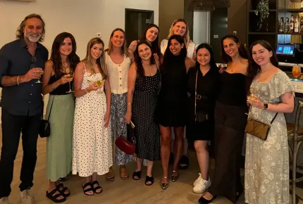 A diverse group of adults holding wine glasses at a nice restaurant for a top creative marketing agency’s retreat. 