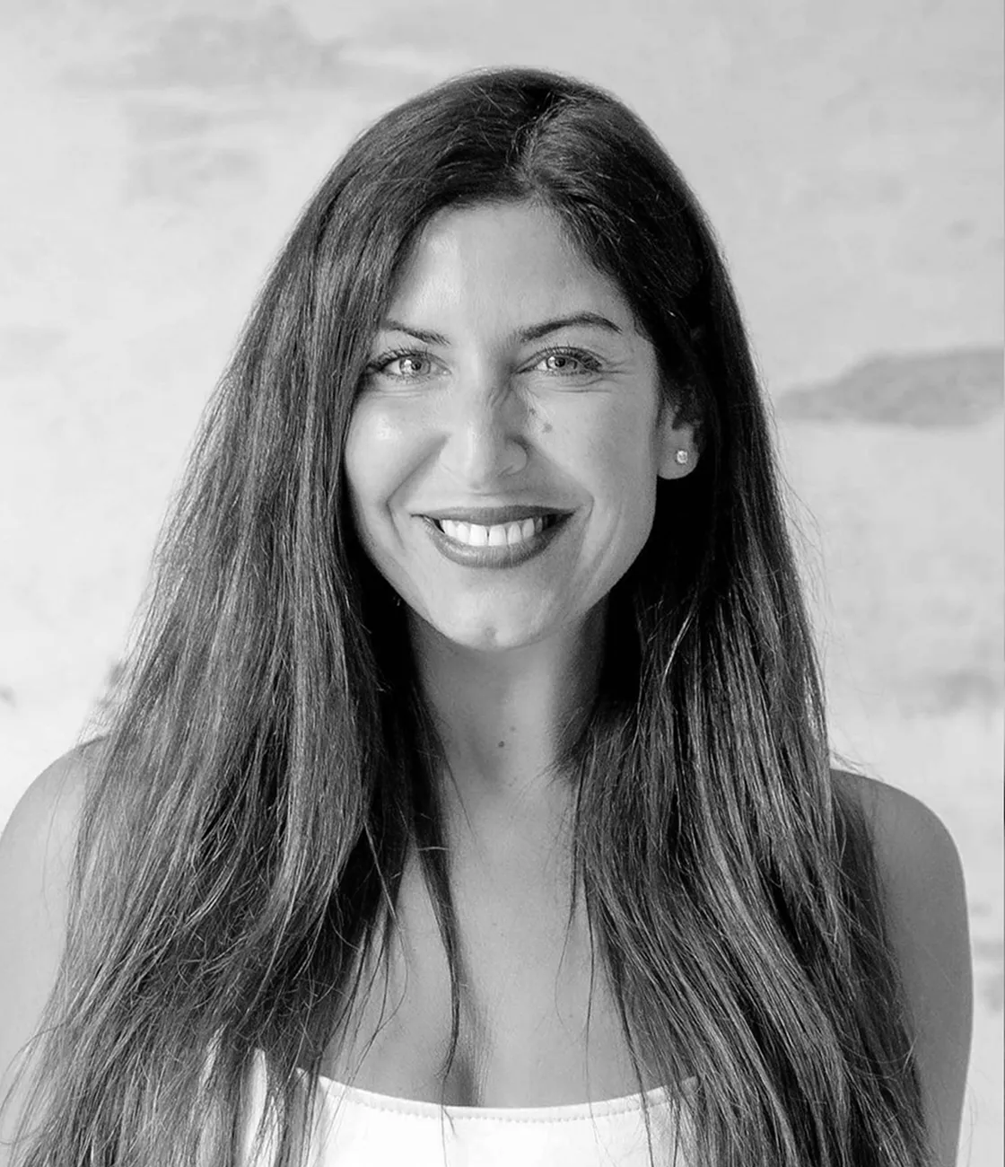 A beautiful female marketing professional, with long brunette hair smiling and wearing dark lipstick. 