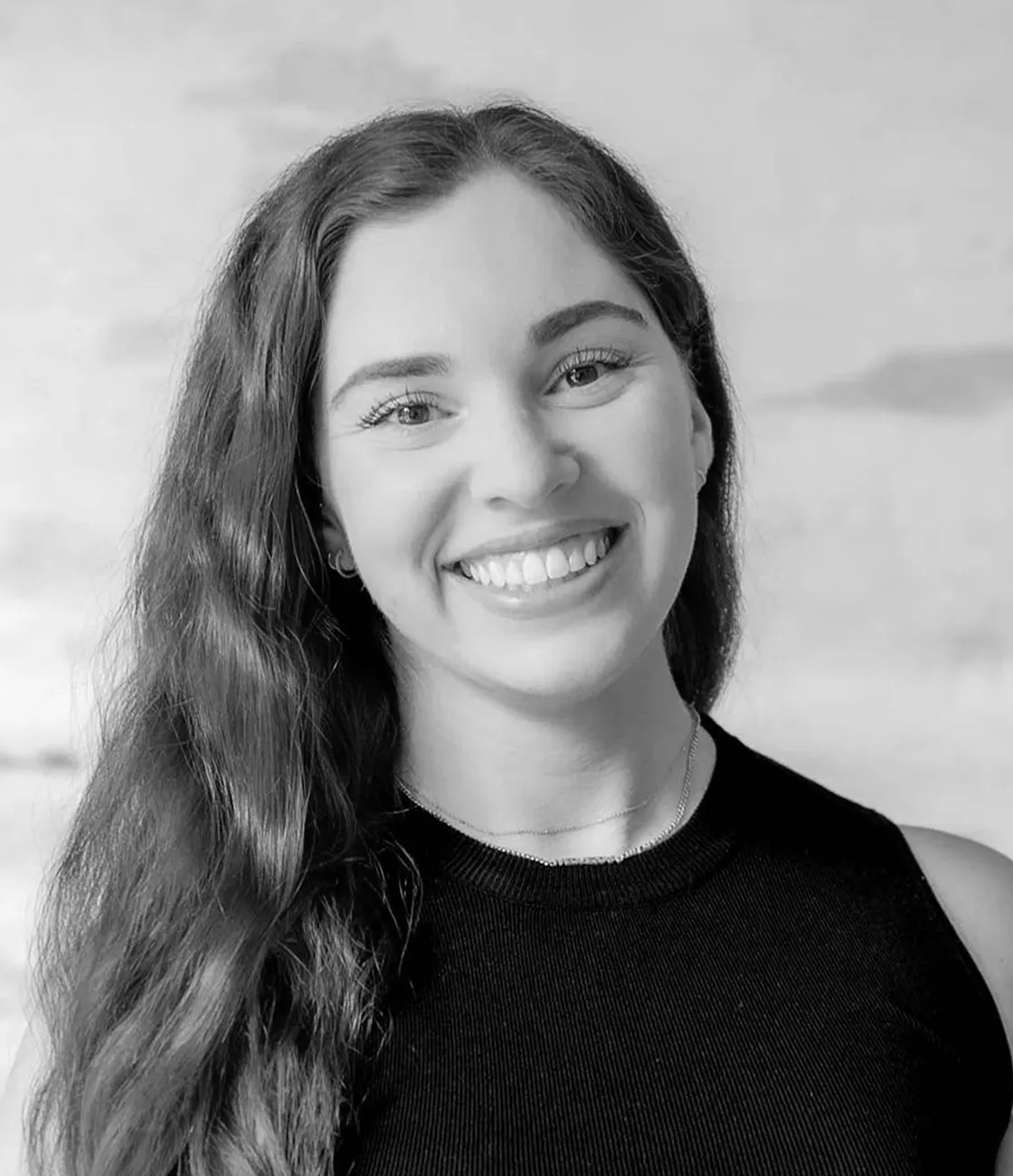 A beautiful Caucasian female marketing professional with long brunette hair smiling.