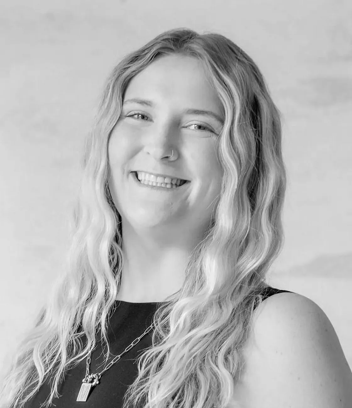 A beautiful young, Caucasian female public relations professional with long blonde hair smiling.