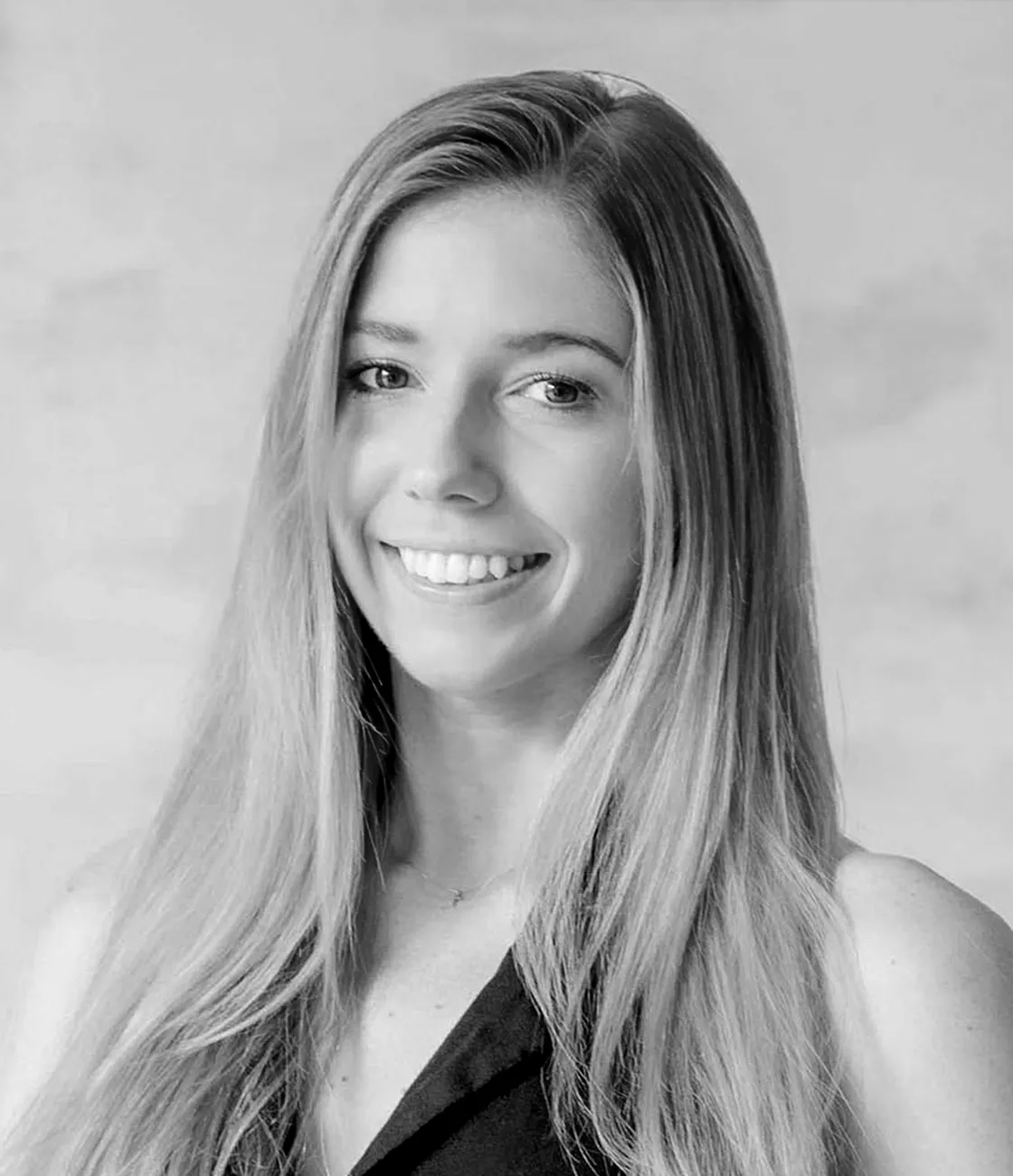 A beautiful young, Caucasian female social media marketing professional with long blonde hair smiling.