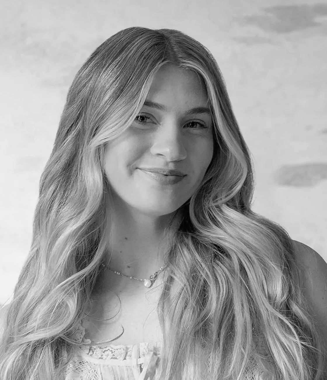 A beautiful young, Caucasian female digital marketing specialist with long blonde hair smiling.