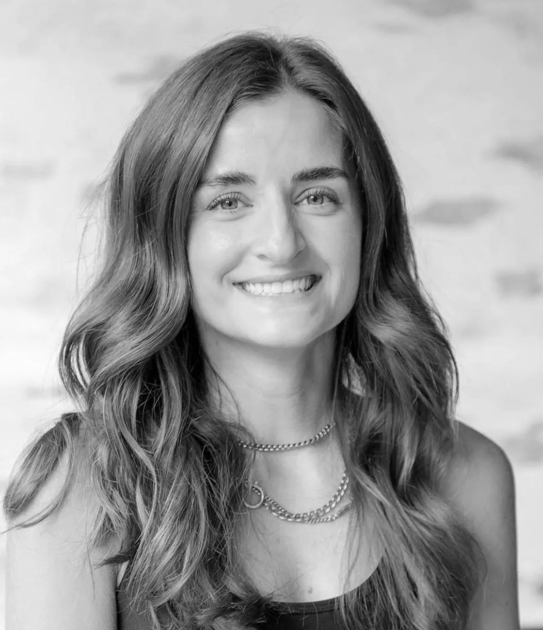 A beautiful Caucasian female graphic designer with long brunette hair smiling.