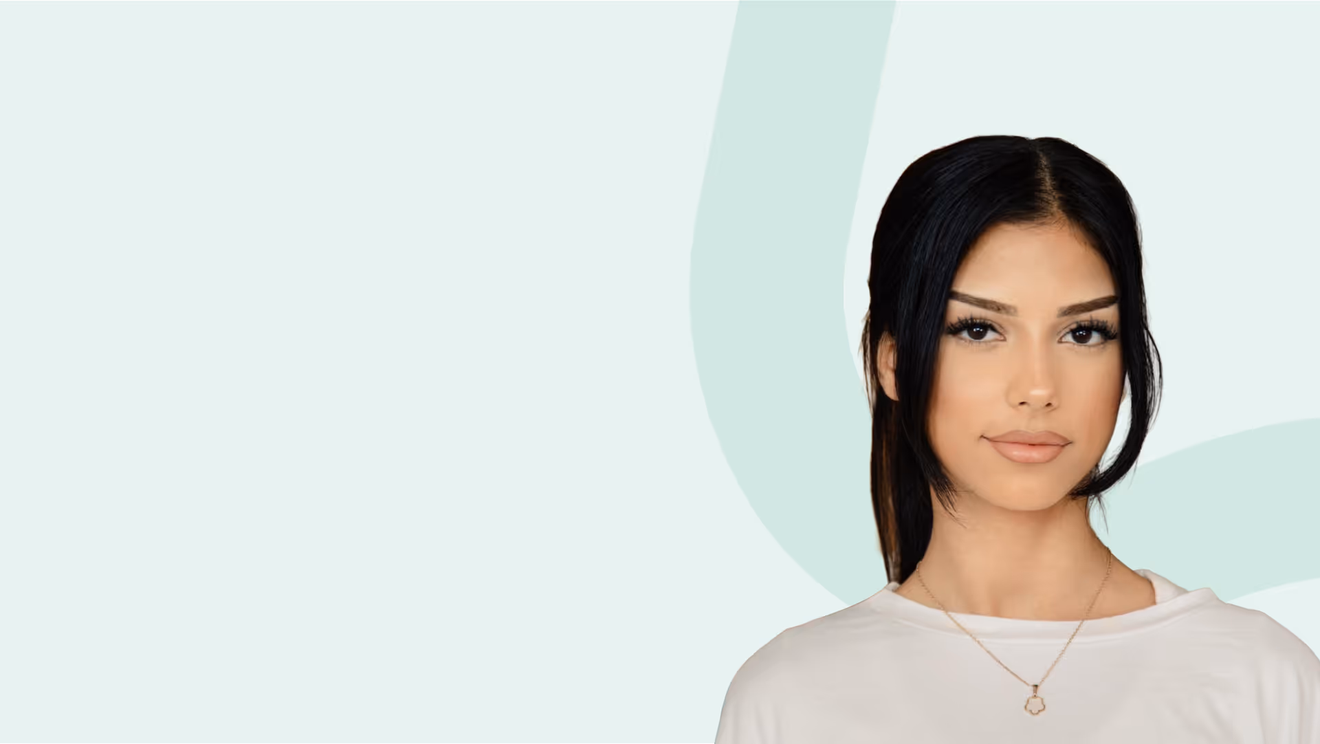 Porträt einer jungen Frau mit schwarzen Haaren in einem weißen Oberteil vor hellem Hintergrund.