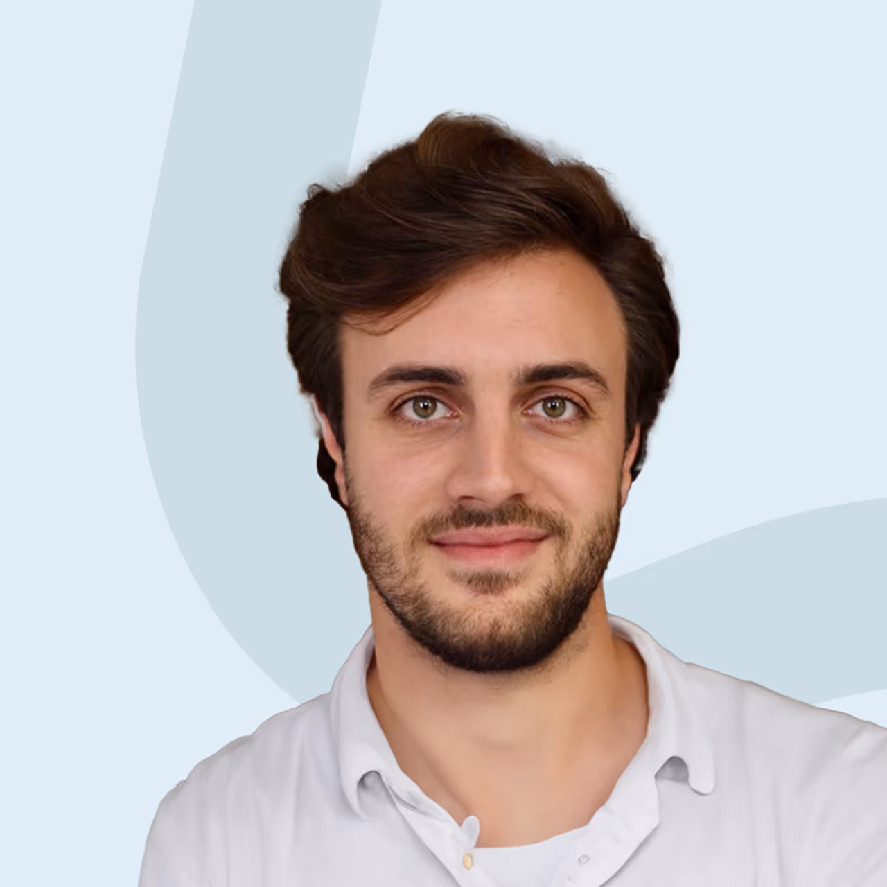 Porträt eines lächelnden Mannes mit braunen Haaren und Bart, der ein weißes Hemd trägt.