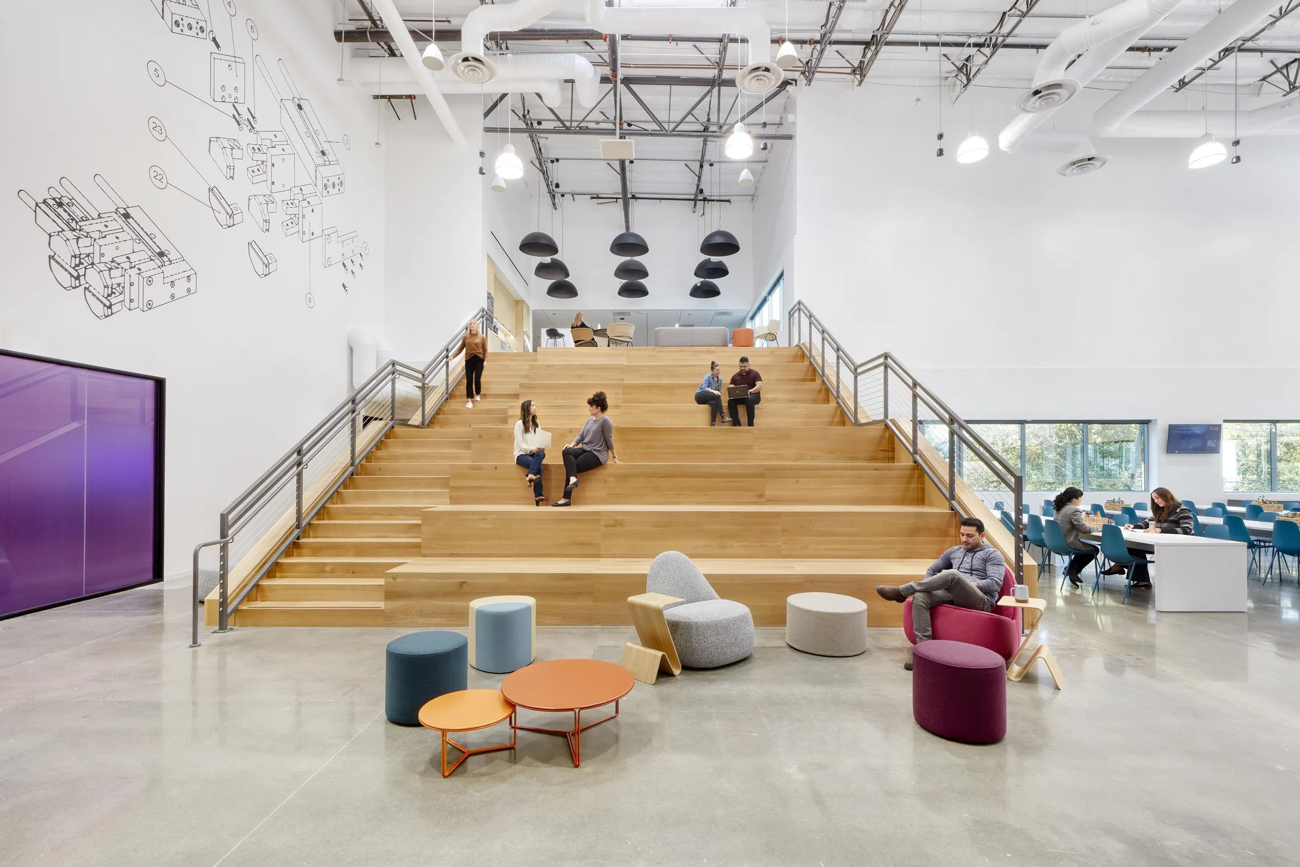 Modern atrium with wooden terraced seating, people sitting and conversing. Vibrant chairs and tables in foreground; wall features abstract line art.