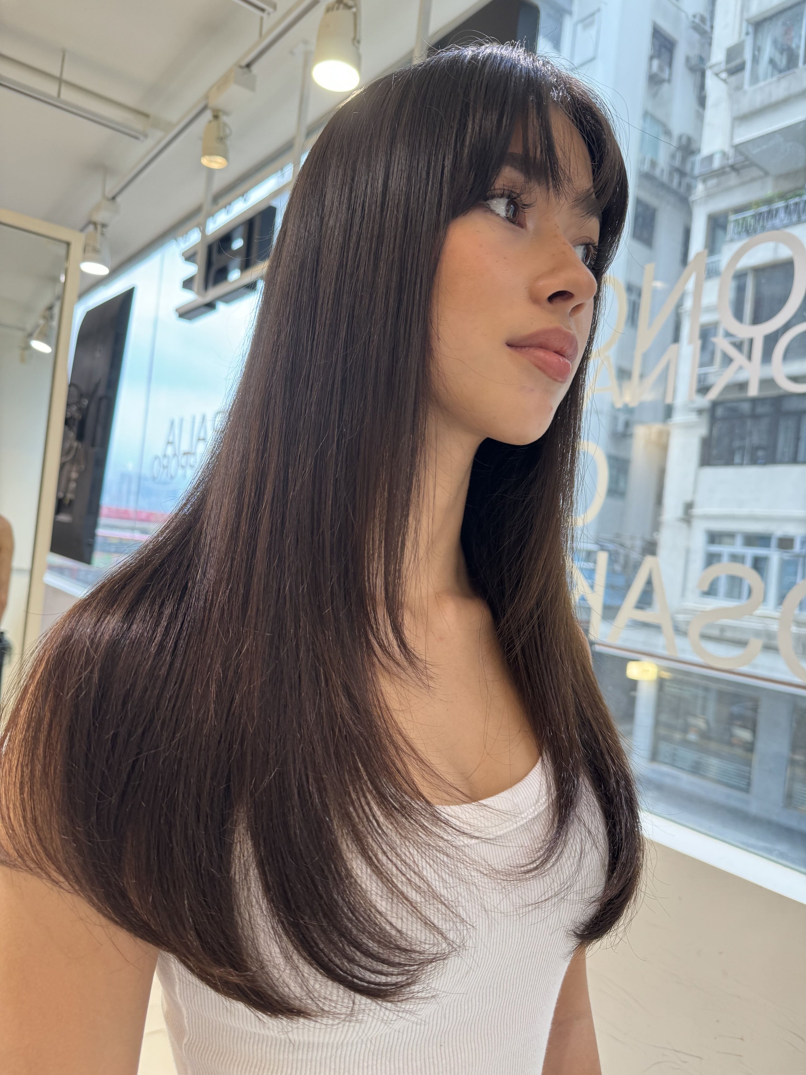 Young woman with long, straight dark hair and bangs.